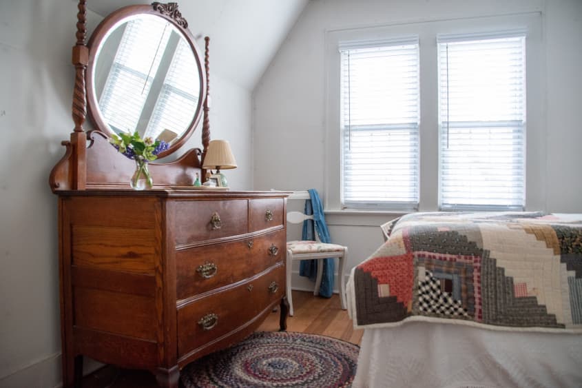 Antique dresser and mirror across from foot of bed