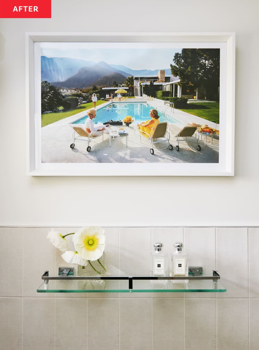 Bathroom after renovation/makeover: detail of framed Slim Aarons photo over glass tray with perfumes, flowers