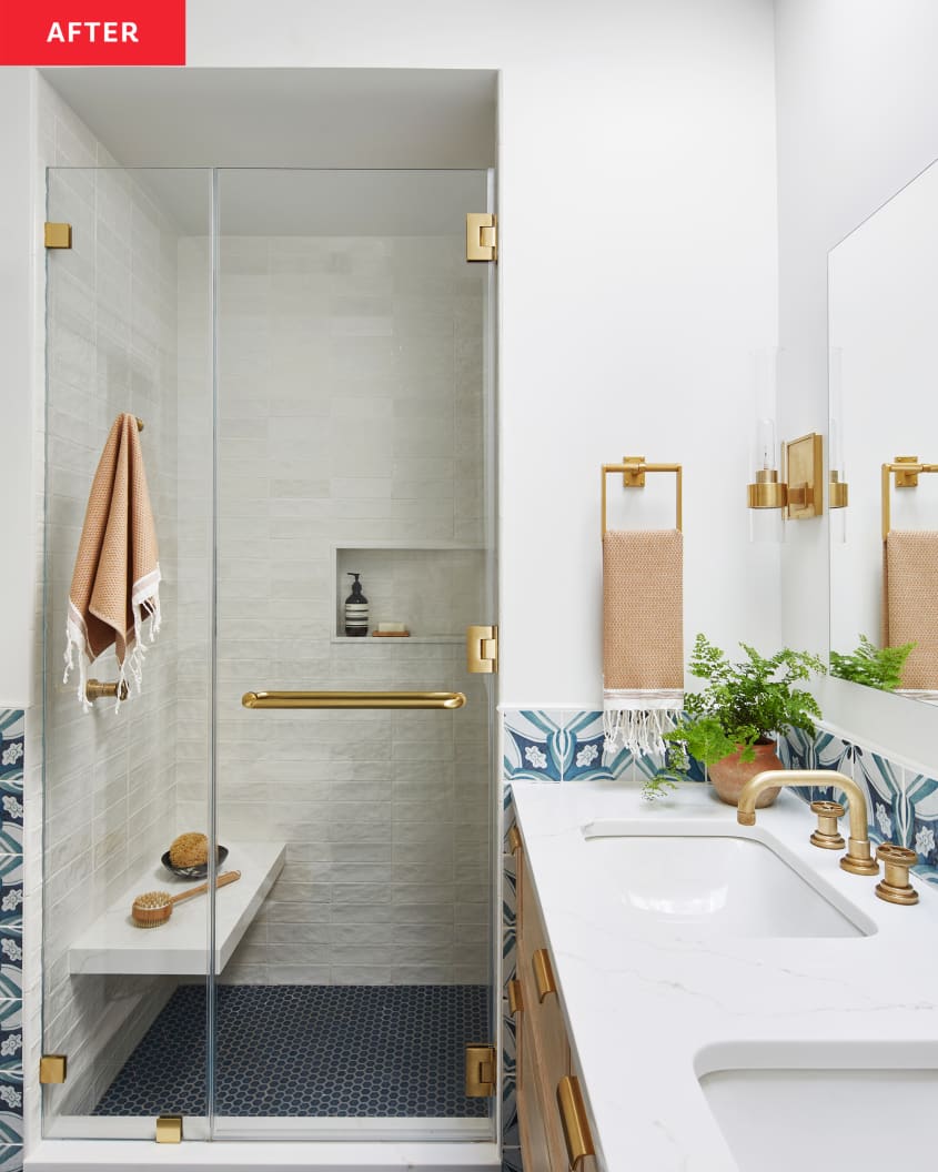 Glass shower door with brass hardware in newly renovated bathroom.