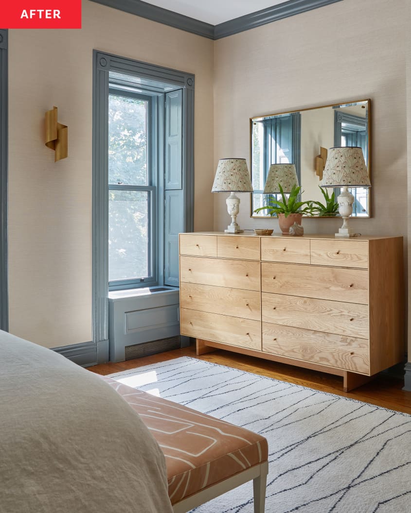 Wooden dresser topped with two lamps in newly renovated bedroom.
