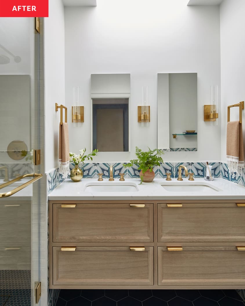 Wooden bathroom vanity with brass fixtures in newly renovated bathroom.