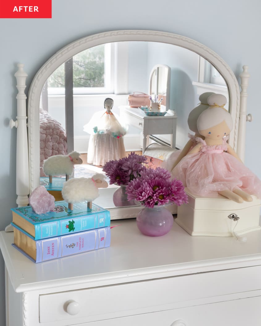 child's dresser, books, mirror attached to dresser, ballerina stuffed toy, purple flowers, white box with key, little sheep stuffed animal