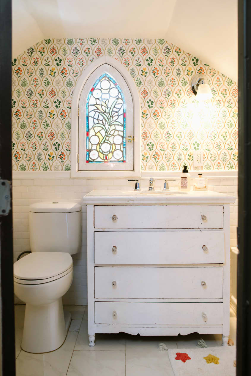 bathroom with floral wallpaper and stained glass window