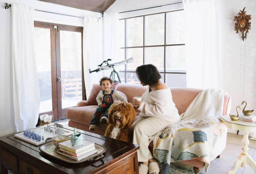 mom, dog, and child sitting together in living room