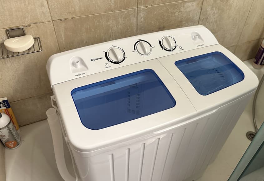 blue and white portable washing machine in tub