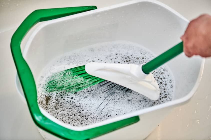 swishing around a broom in a bucket of soapy water