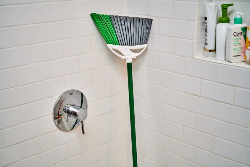 broom standing up in a shower to dry
