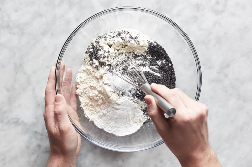 Hands mixing dry ingredients together.
