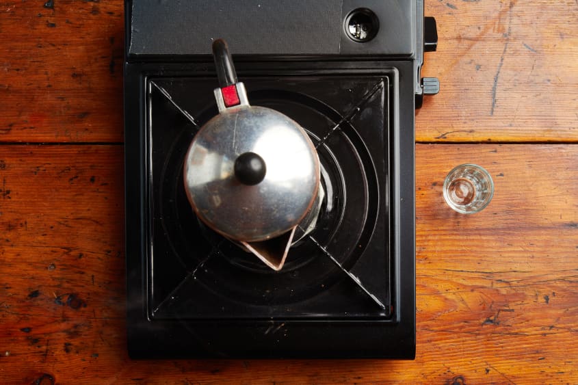 Espresso heating up on propane burner in stovetop espresso maker.