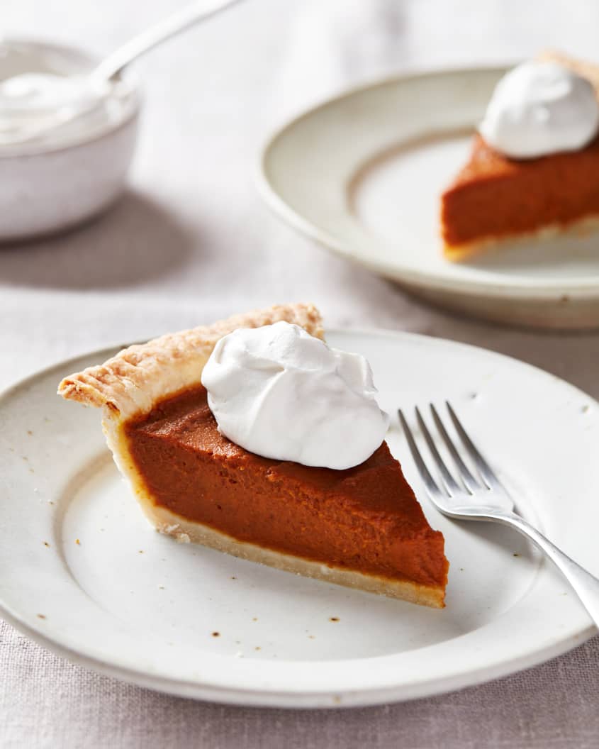 A slice of vegan pumpkin pie is put on a plate and topped with coconut yogurt.