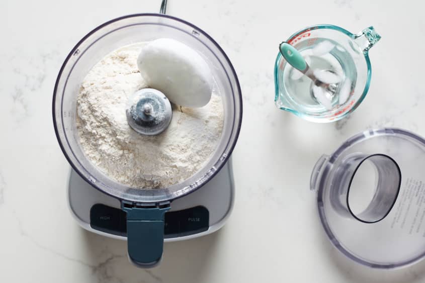 The pie crust ingredients are added to a food processor.