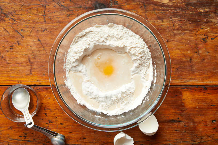 An egg sits in the flour well.
