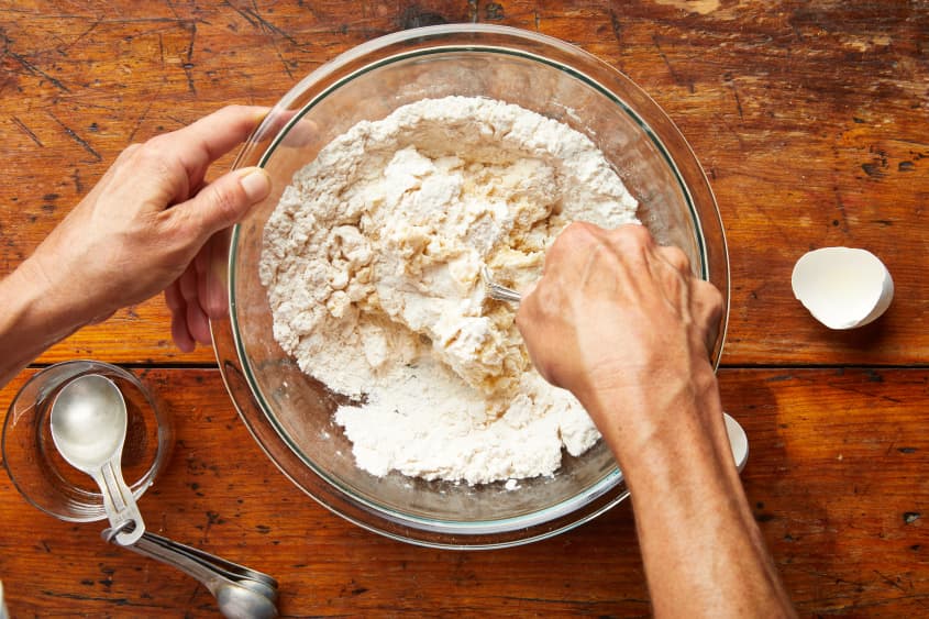 A fork mixes the flour, sugar, and egg mixture.