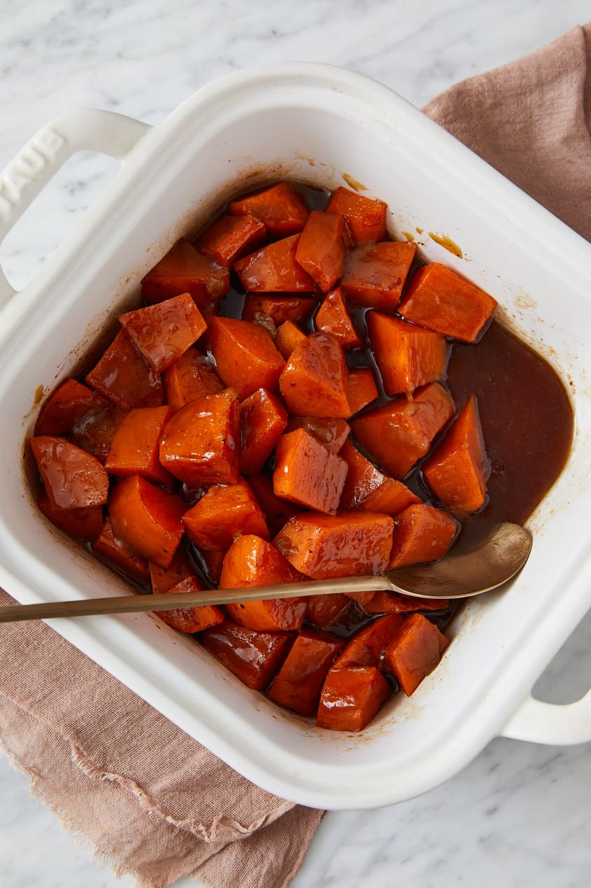 Southern candied yams in baking dish with spoon on side.