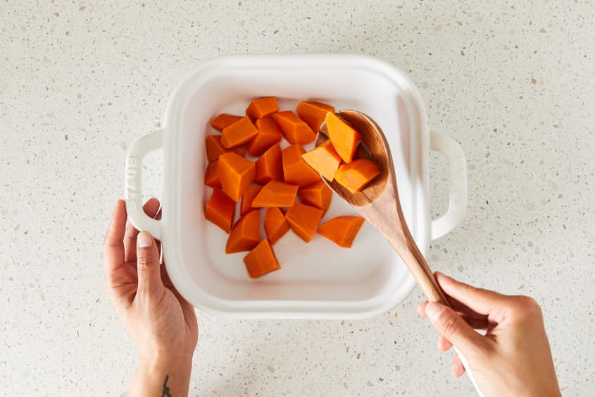 Yams being placed into baking dish.