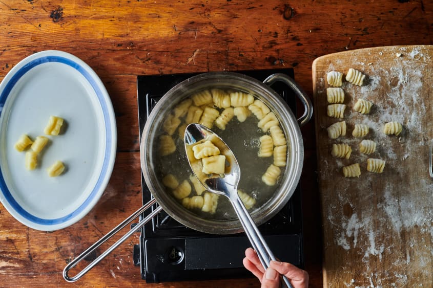 Gnocchi being removed from boiling water.