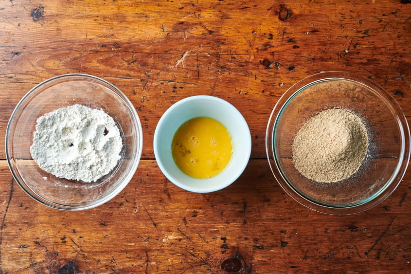 Mise bowls filled with flour, egg, and bread crumbs.