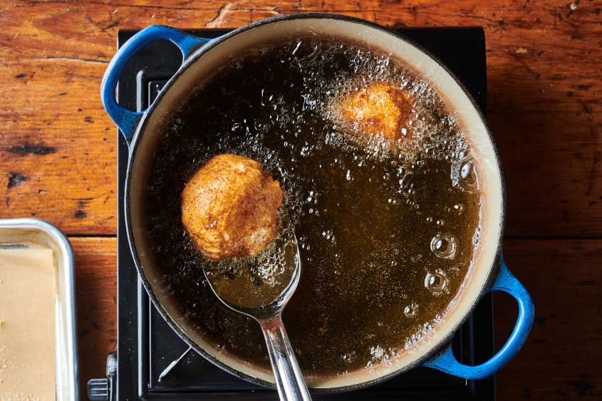 Mashed potato croquettes frying in oil.