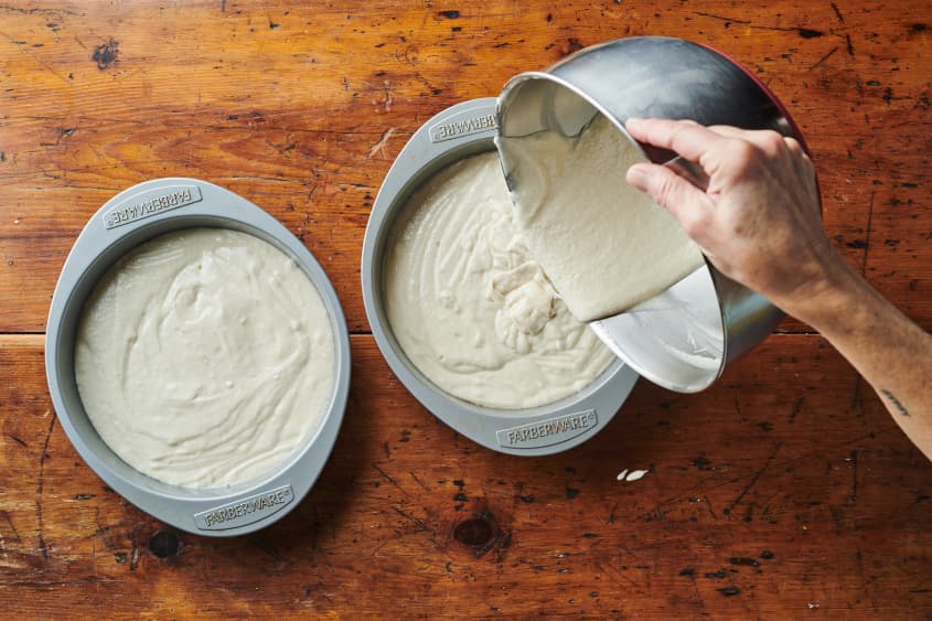White cake batter poured into cake pans.