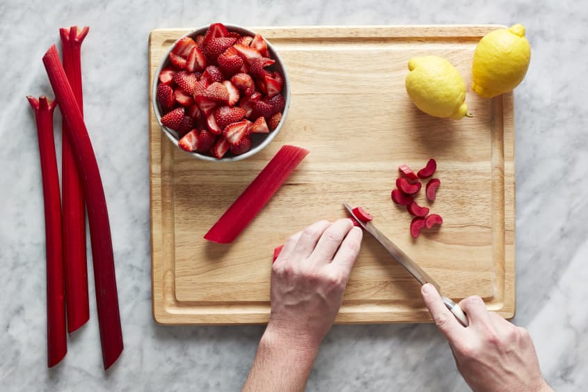 Cutting rhubarb on a cutting board.