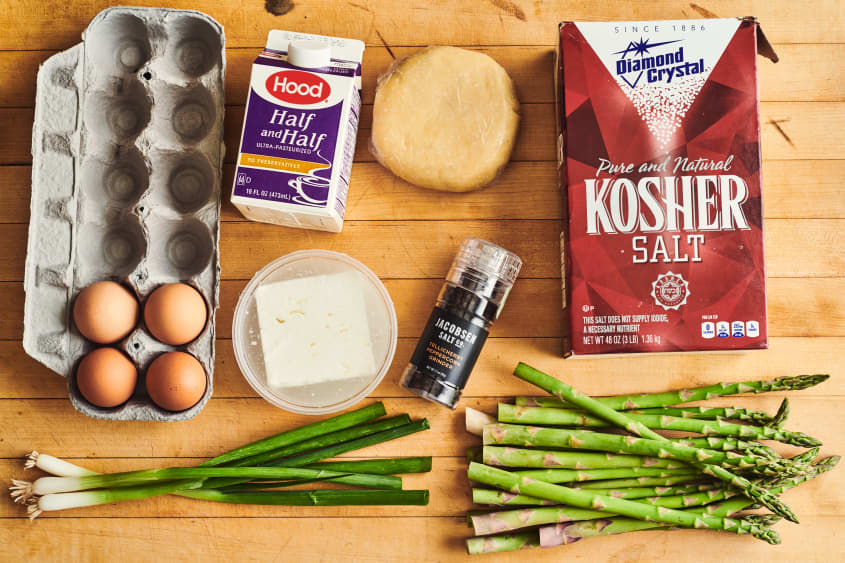 all the ingredients to asparagus quiche laid out on a table