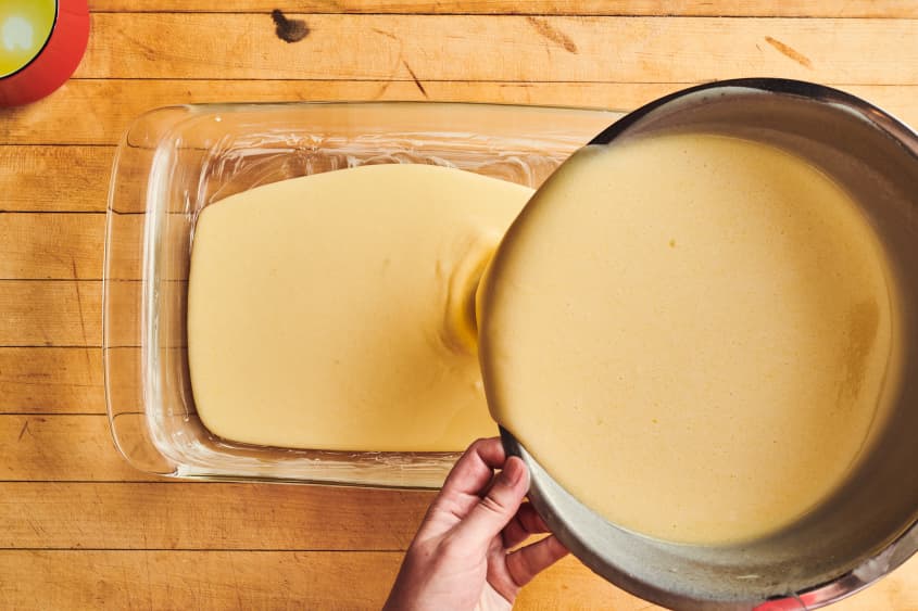 someone is pouring batter into a glass baking dish