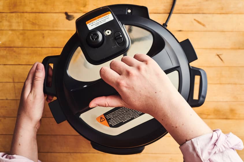 someone is putting the lid on an instant pot