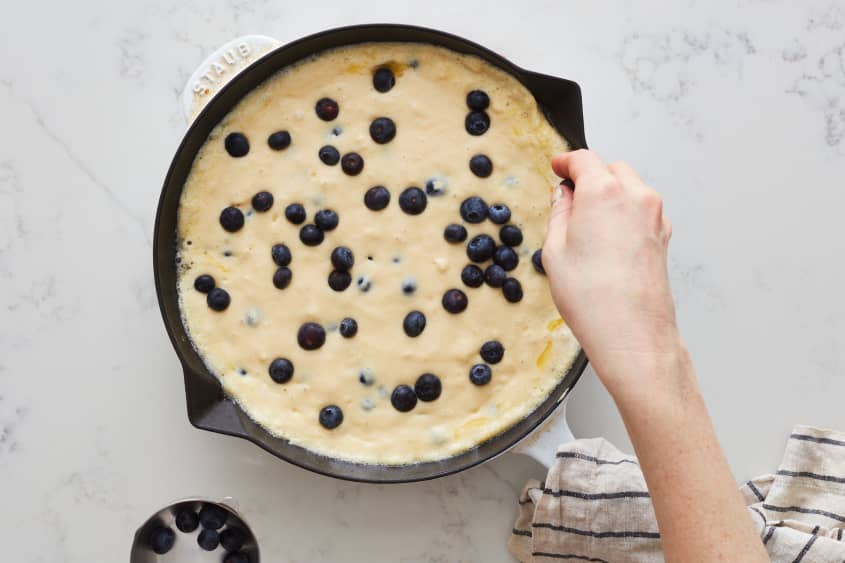 Additional blueberries are added to the pancake.