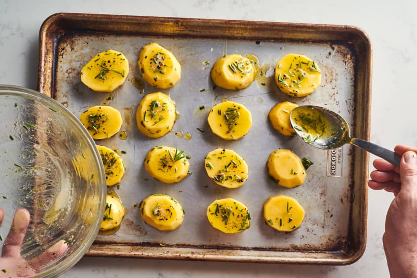 someone is pouring oil on the potatoes