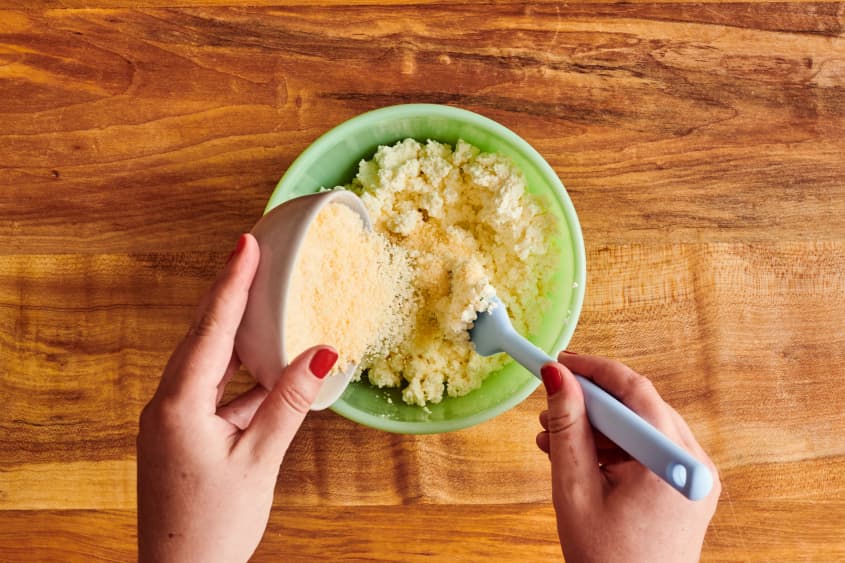Grated parmesan mixing with ricotta.