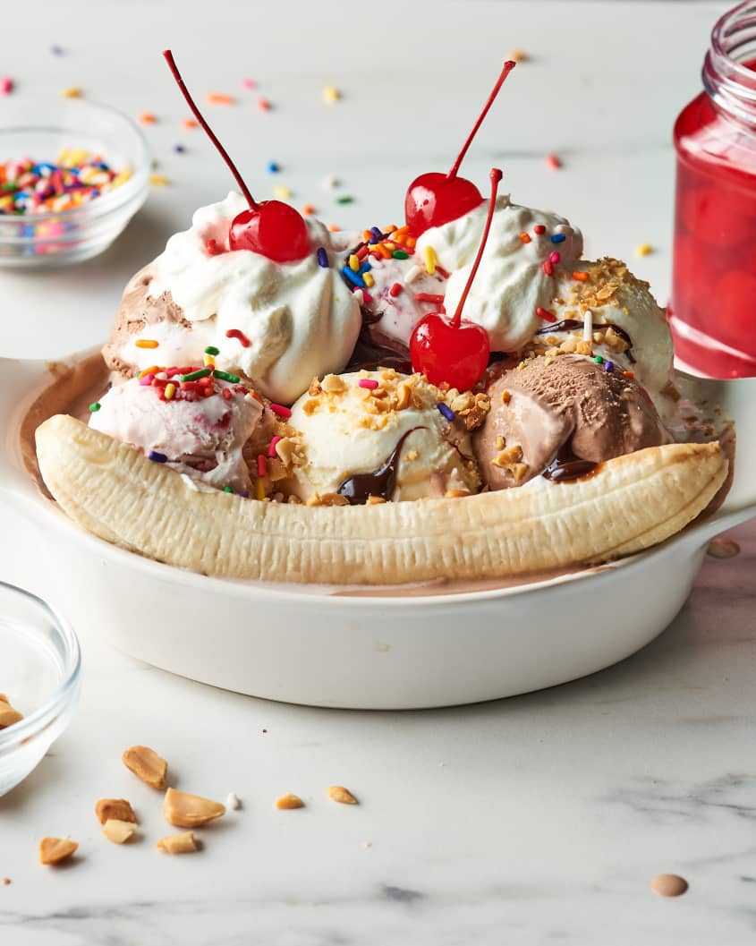 banana split in a  dish topped with cherries