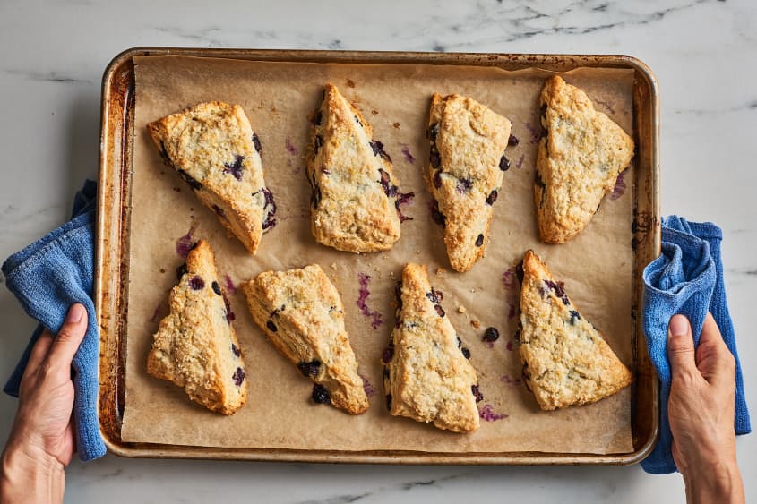 blueberry scones on parchment paper pulled out of the oven