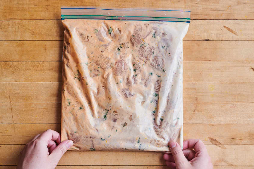 chicken is marinating in a plastic bag