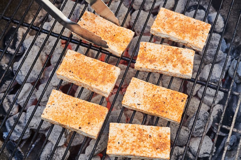 tofu on a grill being flipped