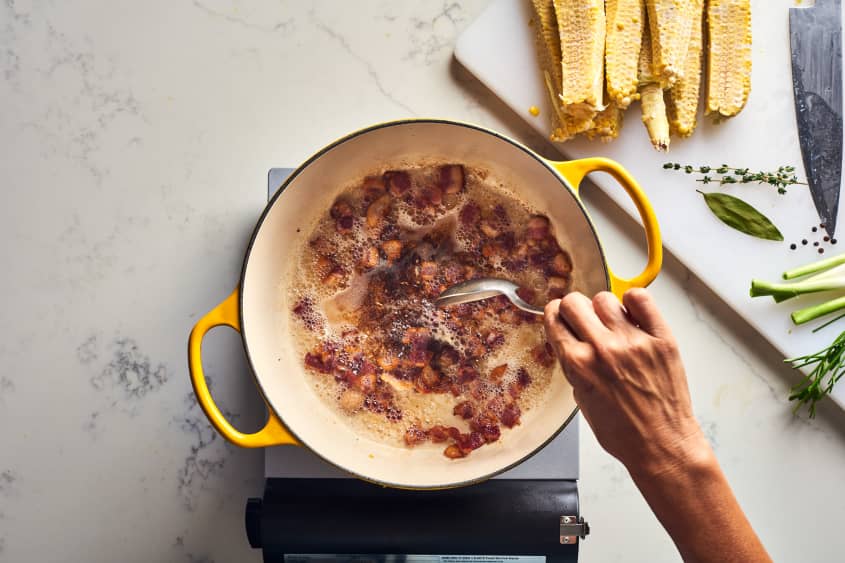 someone boiling bacon in pot