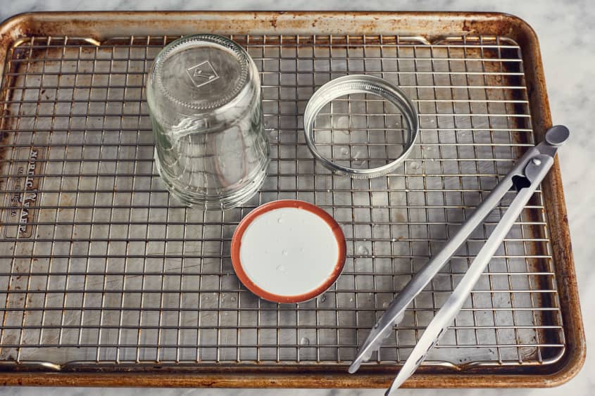 sheet pan, tongs, and a mason jar on a table