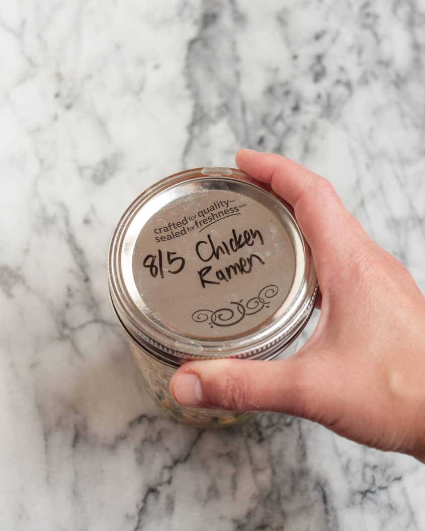 A pint-sized wide-mouth canning jar, with the lid on with '8/5 chicken ramen' words on it