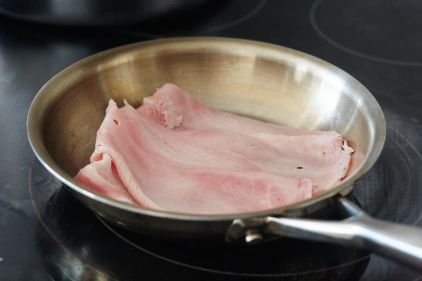 Ham slices in a stainless steel pan