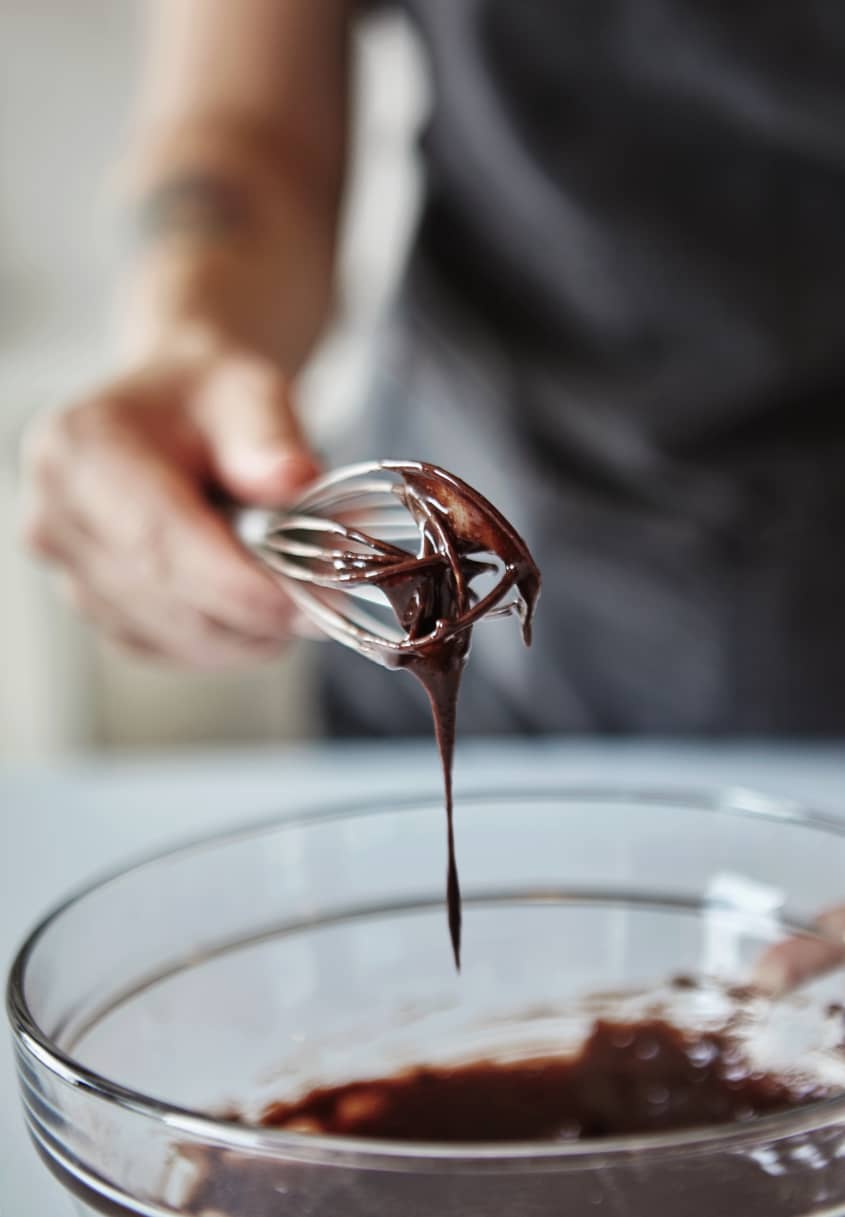 Someone whisks the chocolate in a mixing bowl