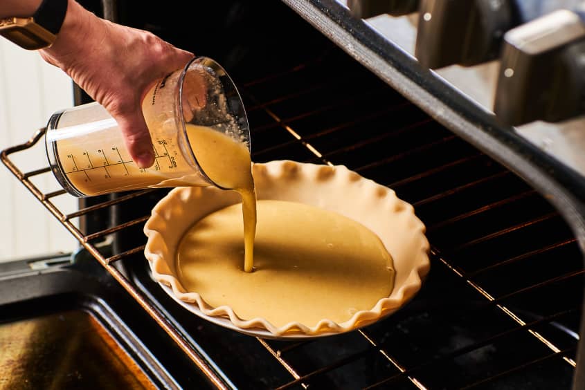 The filling is poured onto the pie crust, which is already placed in the oven