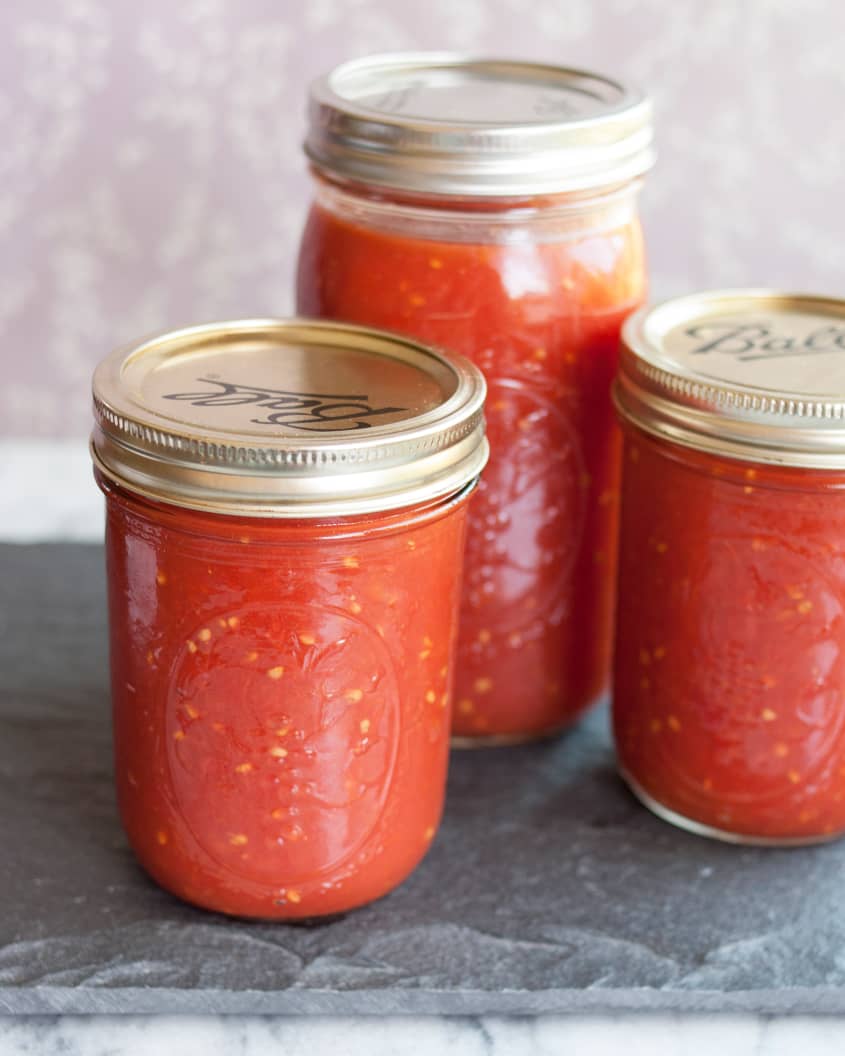 Three mason jars filled with tomato sauce