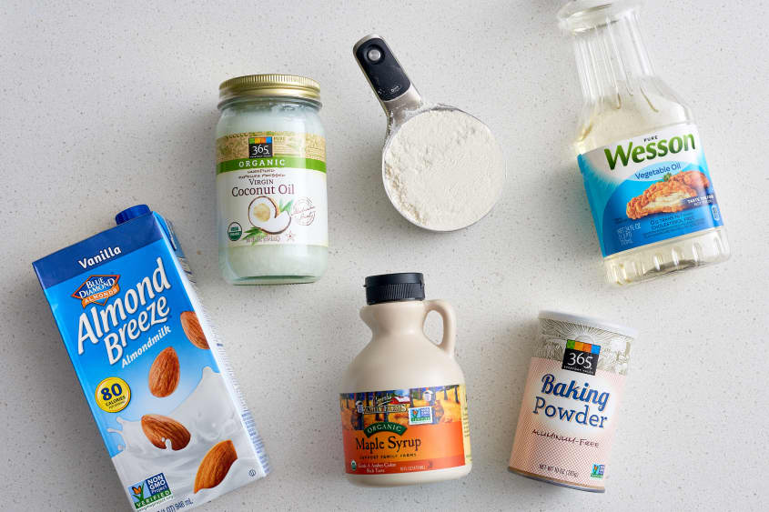 Ingredients for pancakes: almond milk, coconut oil, flour, vegetable oil, maple syrup, and baking powder