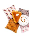 Colorful decorative pillows featuring autumn-themed patterns, including a slice of pie and a cinnamon roll.