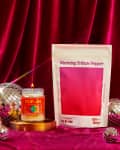 Candle labeled "Fly By Jing" and Warming Tribute Pepper package on red velvet with disco balls.