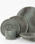 Stoneware dinner set with a rustic finish, including plates, bowl, and cup in earthy tones.