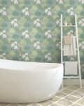 Freestanding bathtub with floral wallpaper and towel ladder in bathroom.