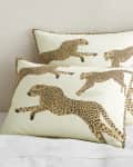 Two pillows with a cheetah print design on a bed with a light-colored wall background.