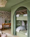 dramatic bunk beds are encased in a green frame in this green and pink bedroom