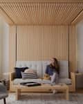 Woman sitting on a modern sofa with a dog, wooden slat wall, city view, and contemporary decor.