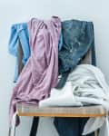 Clothes, including a denim, are hung on a chair